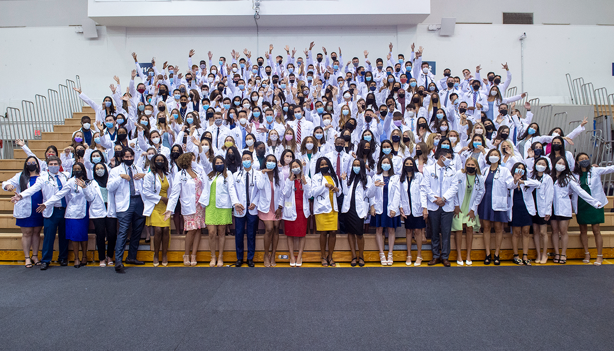 Students in the SOM Class of 2025 stand together in a group on the bleachers in McDonough Arena