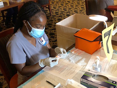 A person in medical garb works at a table