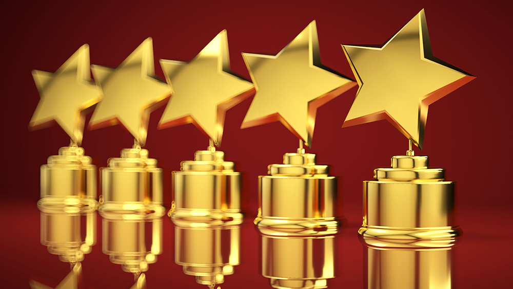 Photoillustration of star shaped awards in a row against a red background