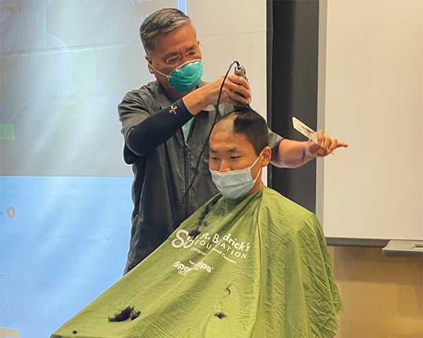 A man has his head shaved