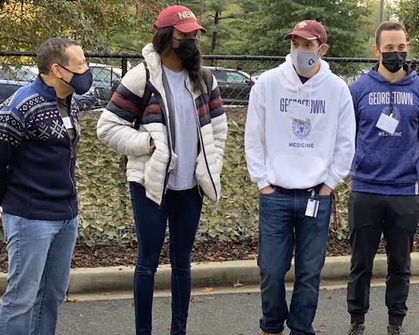 Four people stand together outdoors