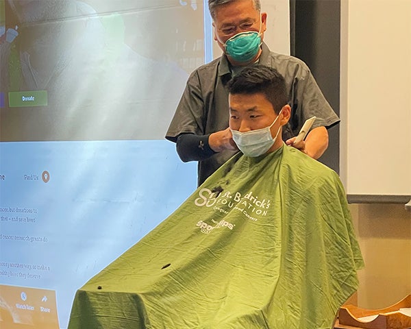 A man prepares to have his head shaved