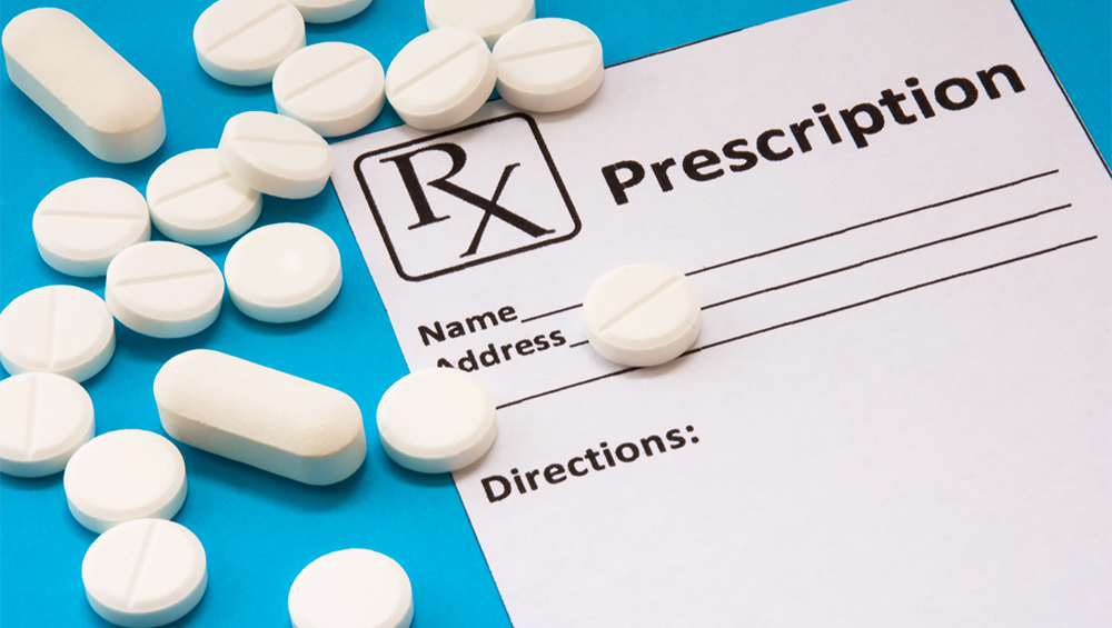 A photoillustration of a blank prescription with pills