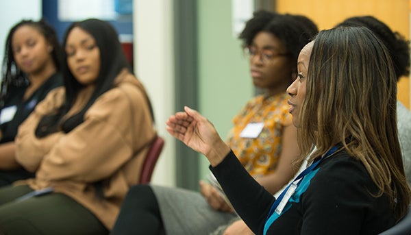 A doctor address students in a roundtable discussion