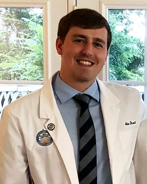 Alex Strait in his white coat