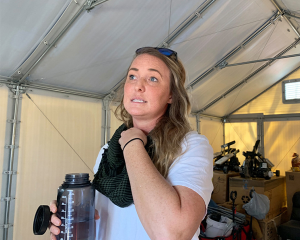 Helen Perry stands in a tent holding a water bottle