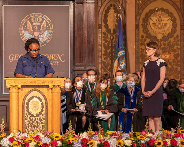 Lt. Cmdr. Adeyeye speaks from the podium as Brynley Dean looks on