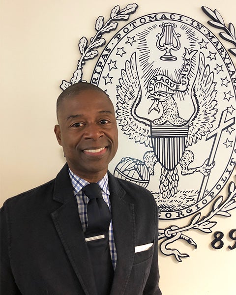 Brian Floyd stands in front of the Georgetown seal