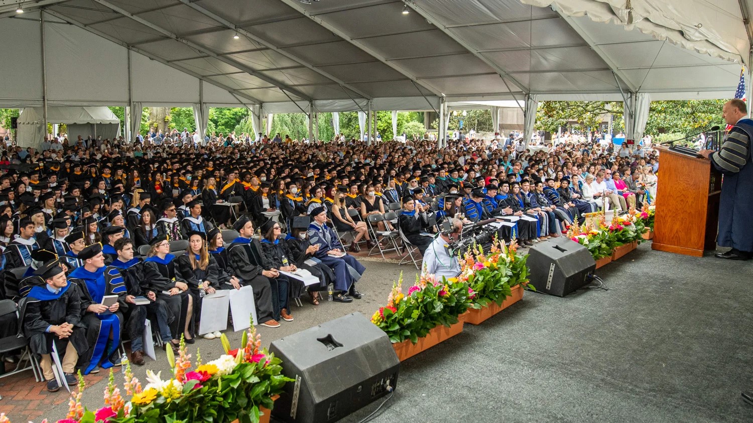 Graduate students gather in a large tent for commencement