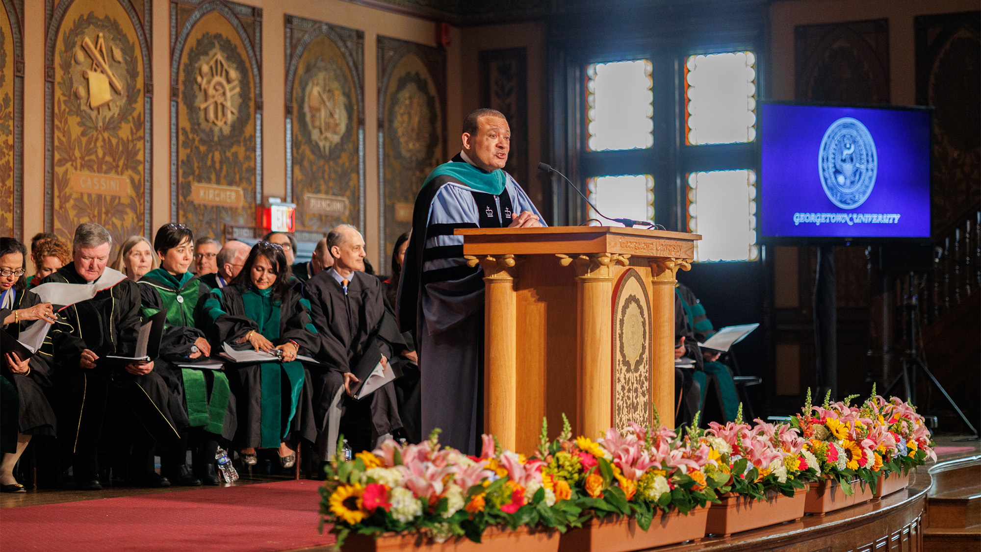 Dean Jones speaks from the stage in Gaston Hall, where faculty of the School of Medicine are seated