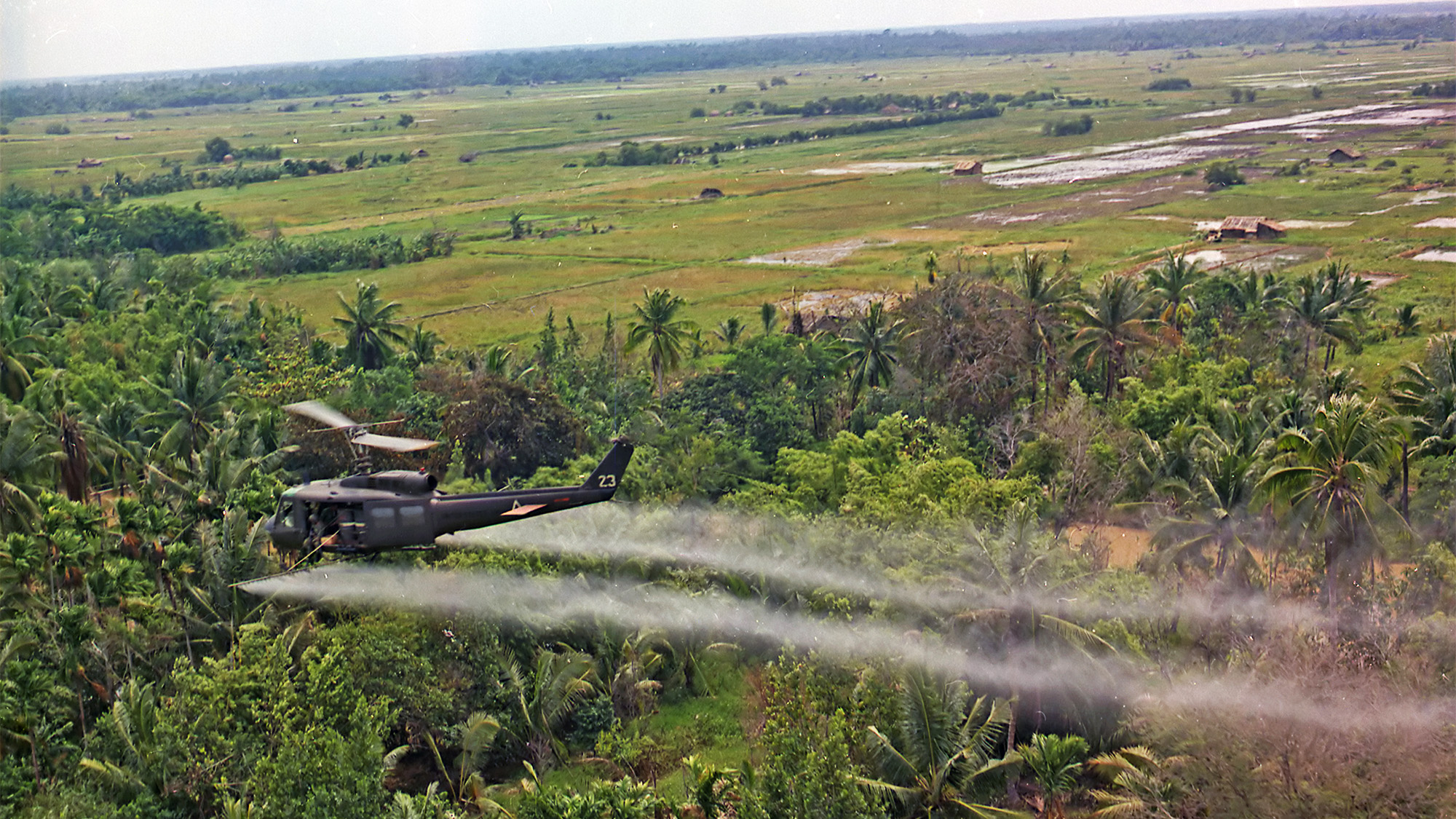 A helicopter sprays herbicide on a Mekong Delta area