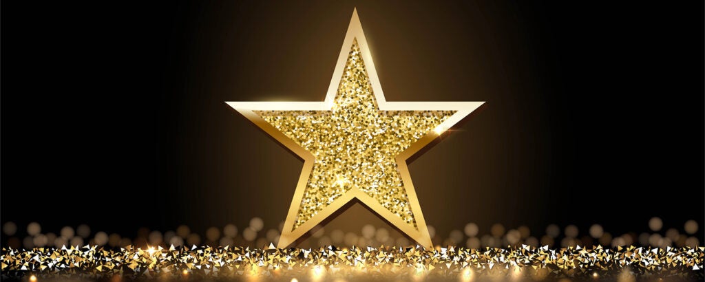 Glittery gold star on glittery gold surface