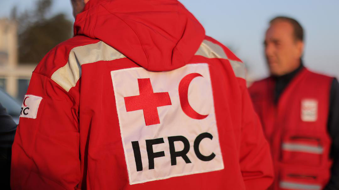 Two people wear red IFRC jackets