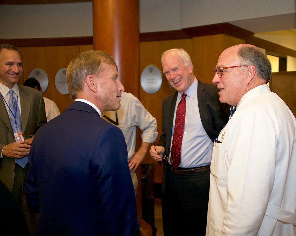 A group of men stand together at a reception