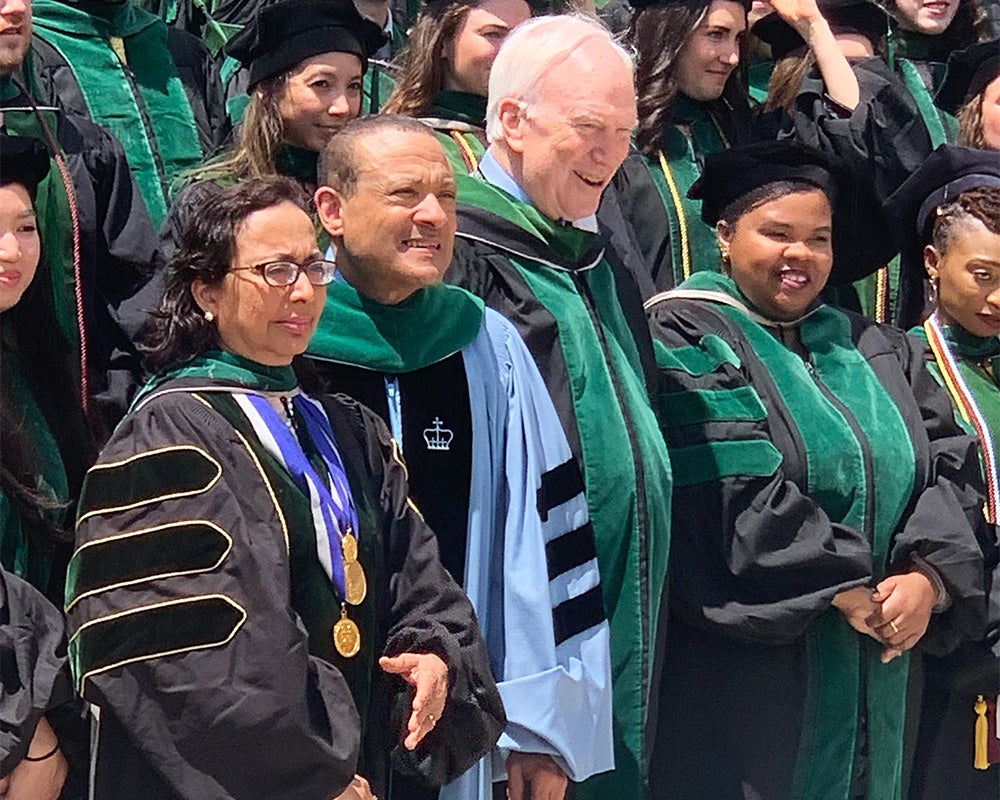 Commencement participants stand side by side in academic regalia