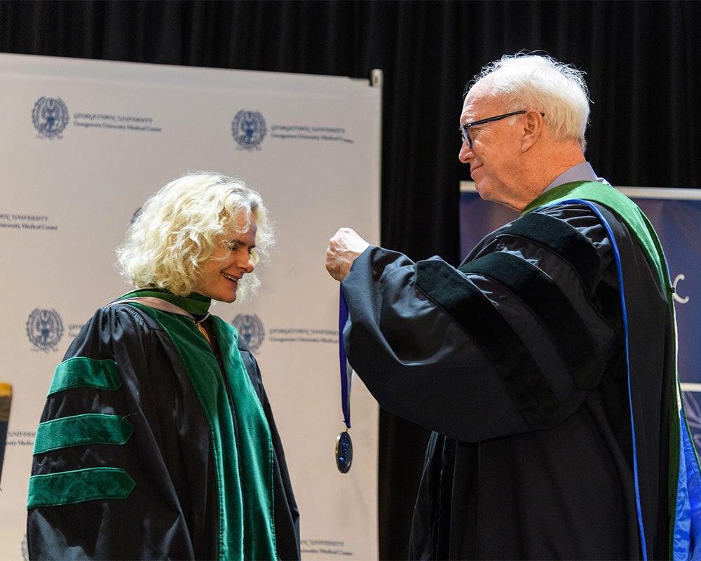 Dr. Healton places a medal over Nora Volkow's head