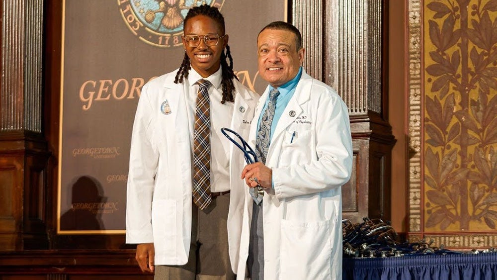 Dylan Hughes stands next to former dean Lee Jones at his white coat ceremony