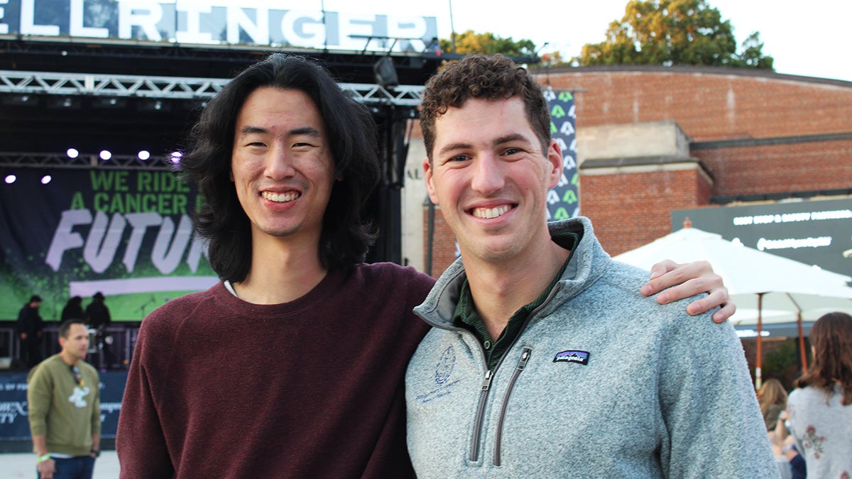 Two students stand with the BellRinger opening ceremony stage behind them