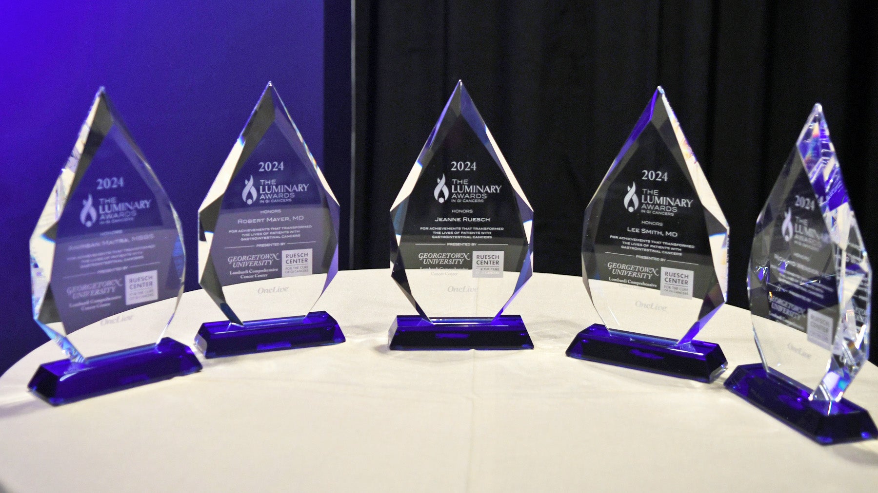 Five glass Luminary Awards sit on a white-tableclothed table