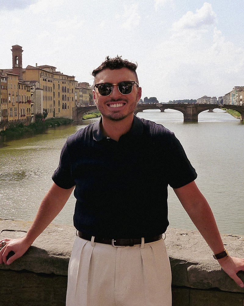 Bryson Daniels-Stevens stands on a bridge with a river behind him