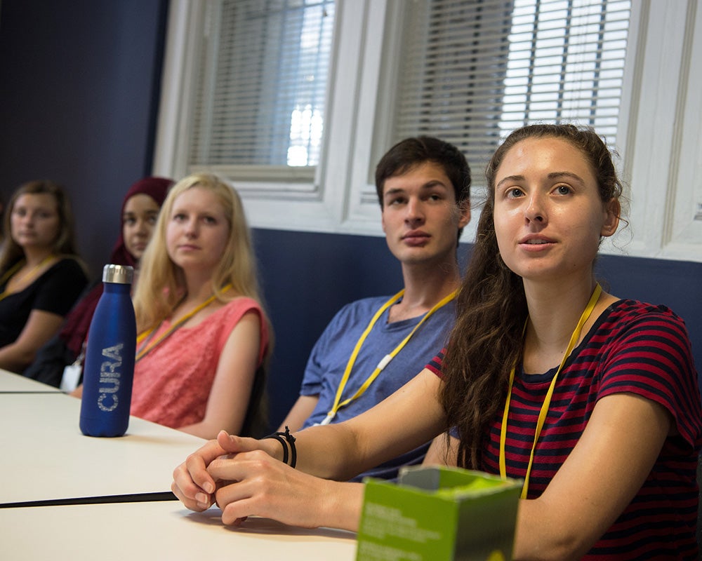 Student participants in the CURA Program sit at a table