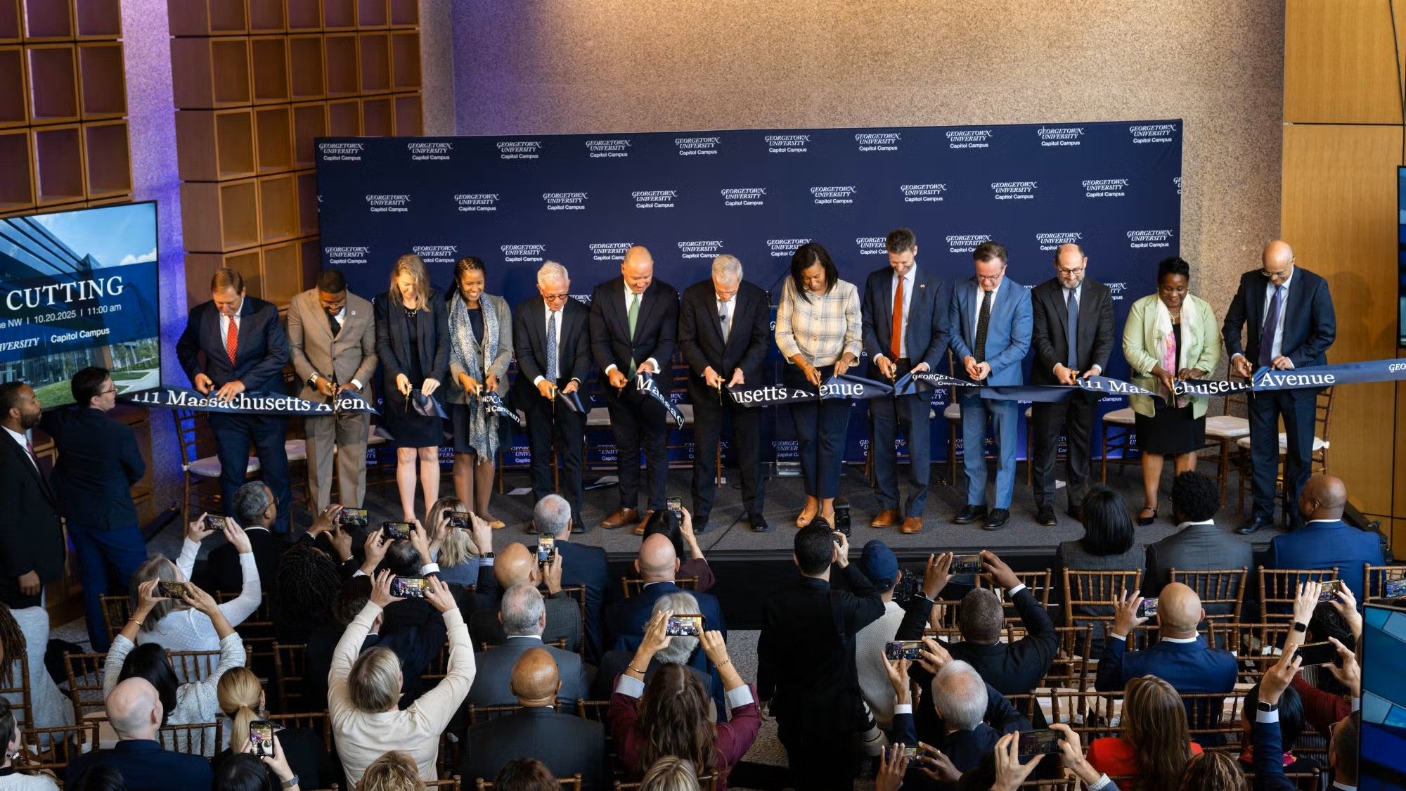 A group of individuals cuts a ceremonial ribbon at the 111 Mass Ave. dedication ceremony.