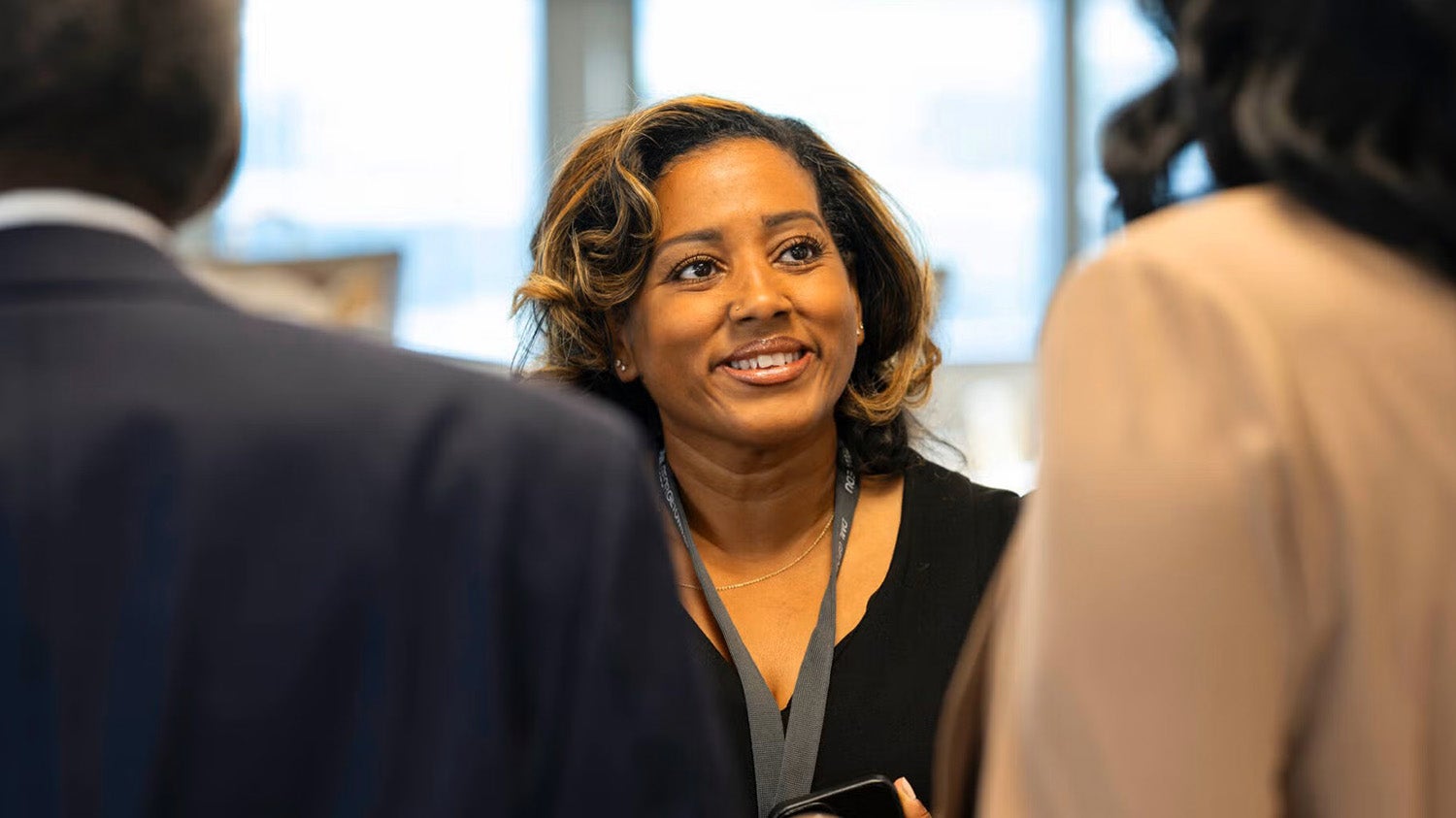 Kenyatta Hazlewood speaks with a fellow PhD student and her father at the program's opening reception
