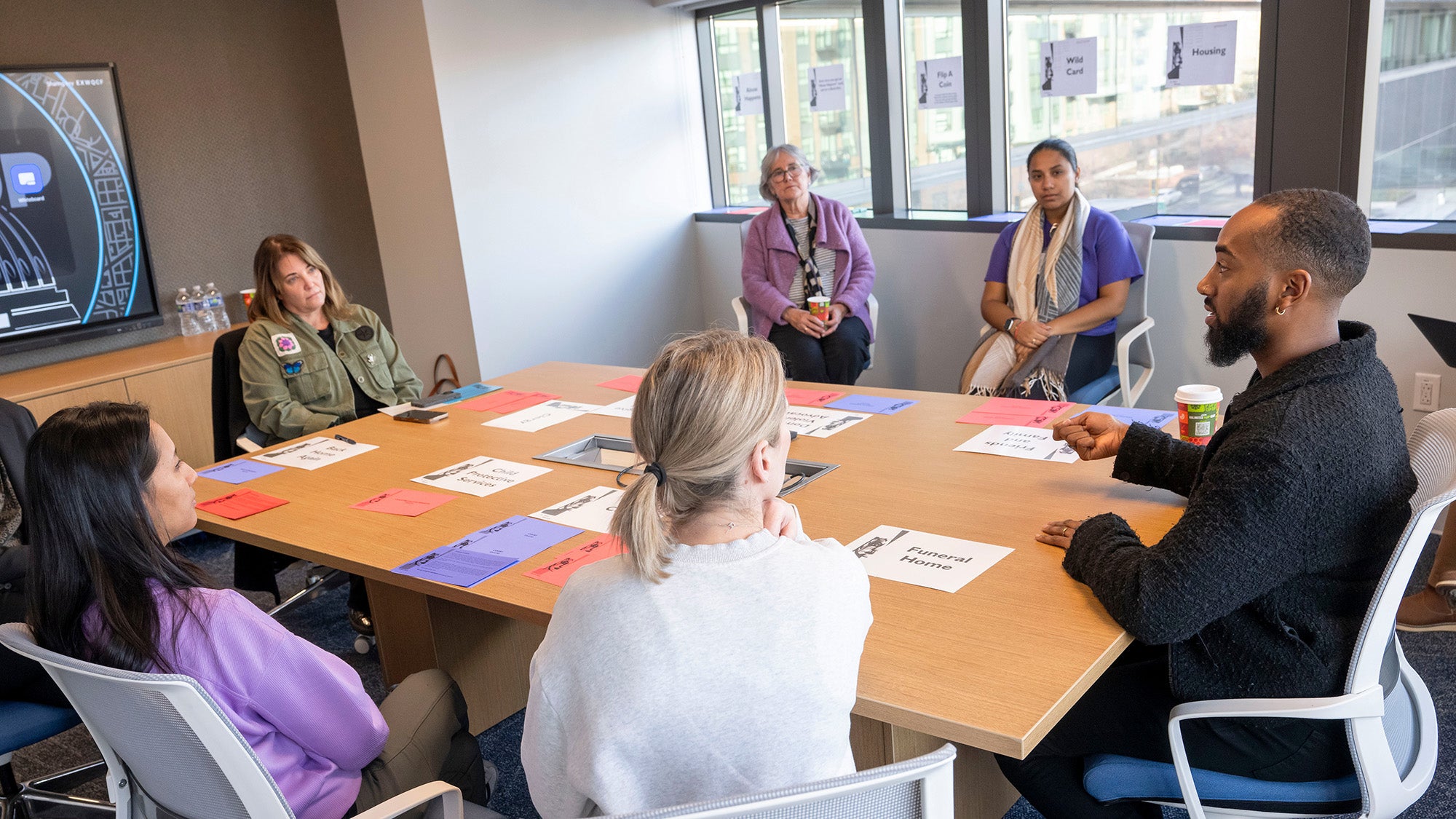 Several students and faculty members in the PMHNP Certificate Program sit at a table and talk