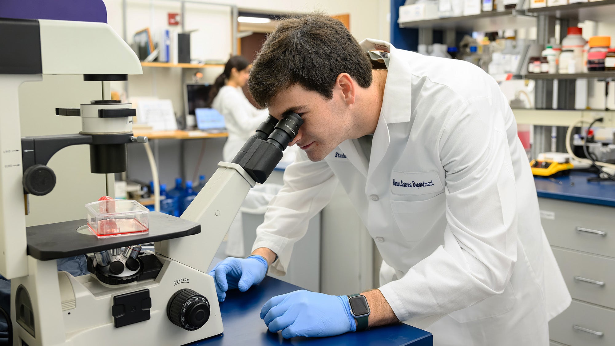 A School of Health student looks through a stereomicroscope in the Discovery Center