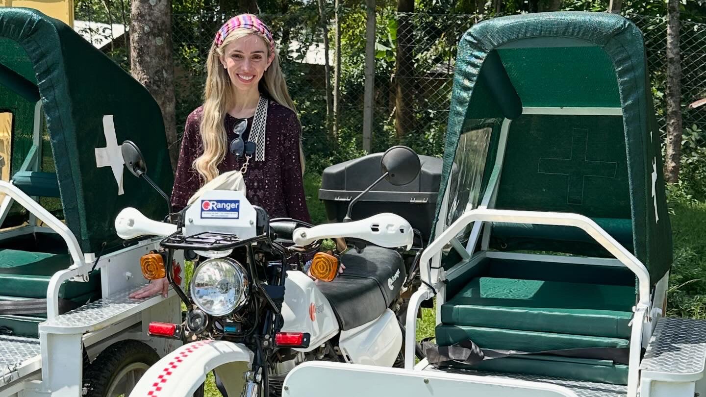 Alex Jones stands next to a motorbike ambulance