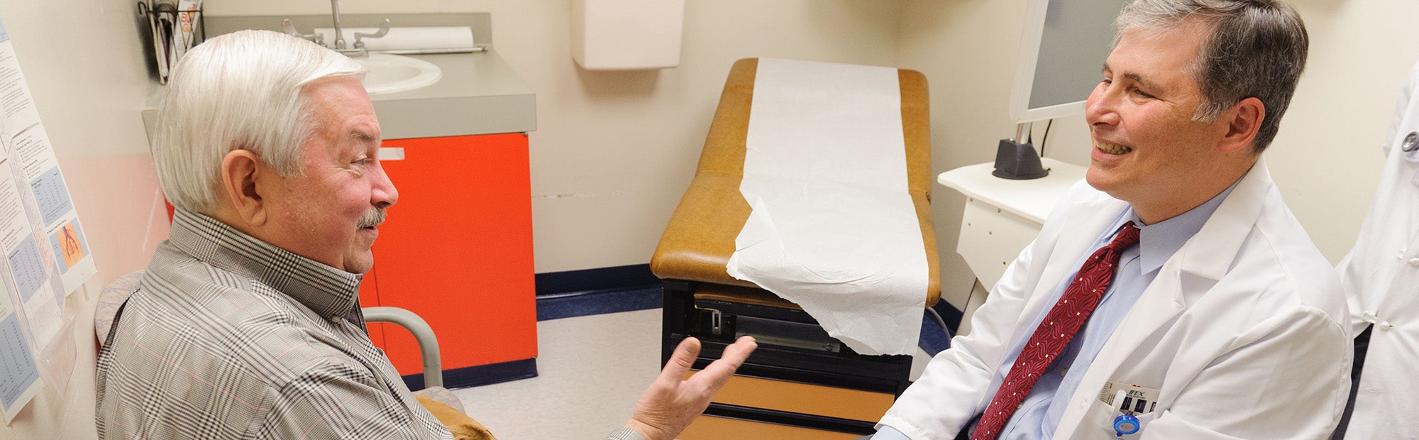 A doctor converses with his male patient