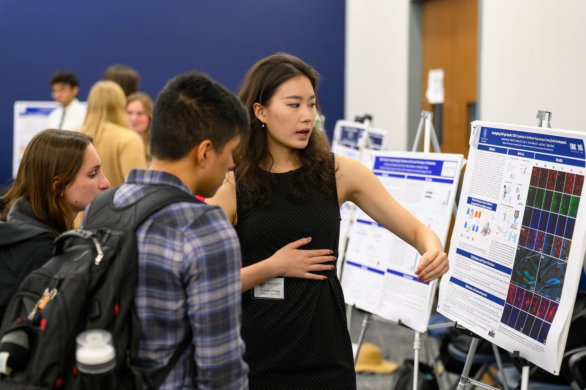 A female student explains her poster at the Undergraduate Research Conference