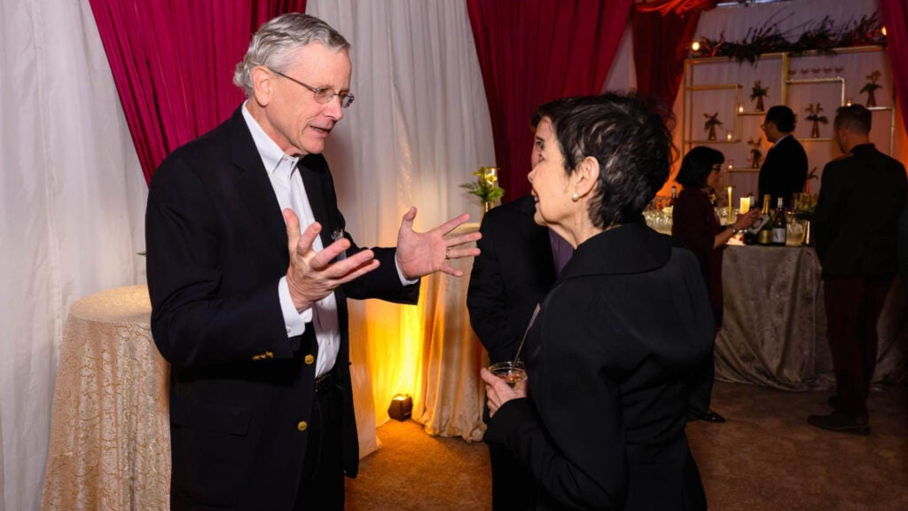 John Monahan speaks with two guests at a gathering