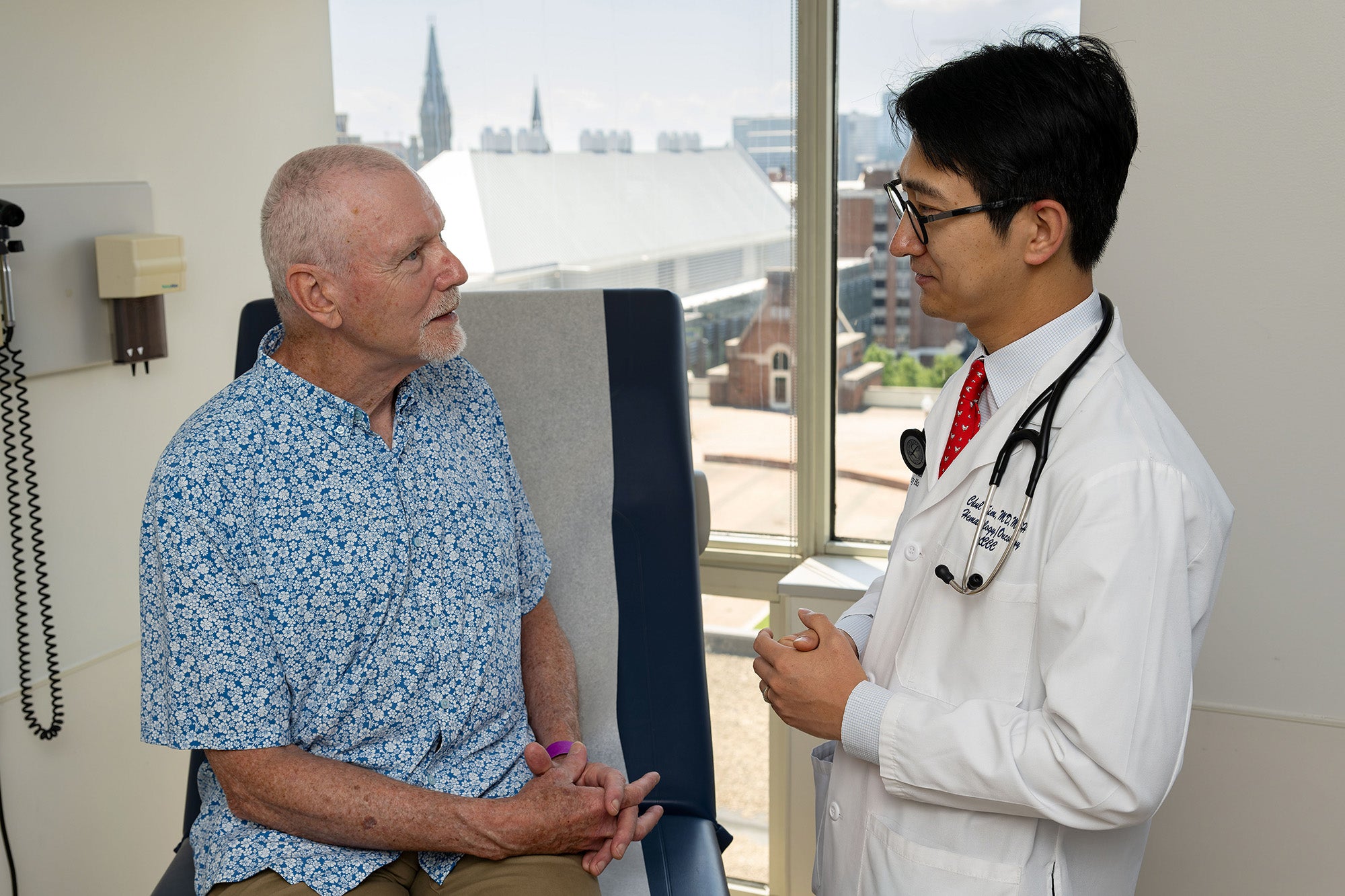 Dr. Chul Kim speaks to a patient in an exam room