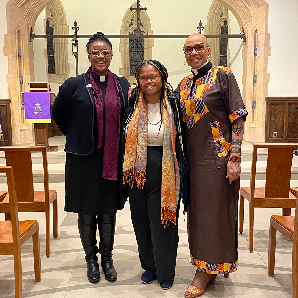 Three individuals stand together in a church