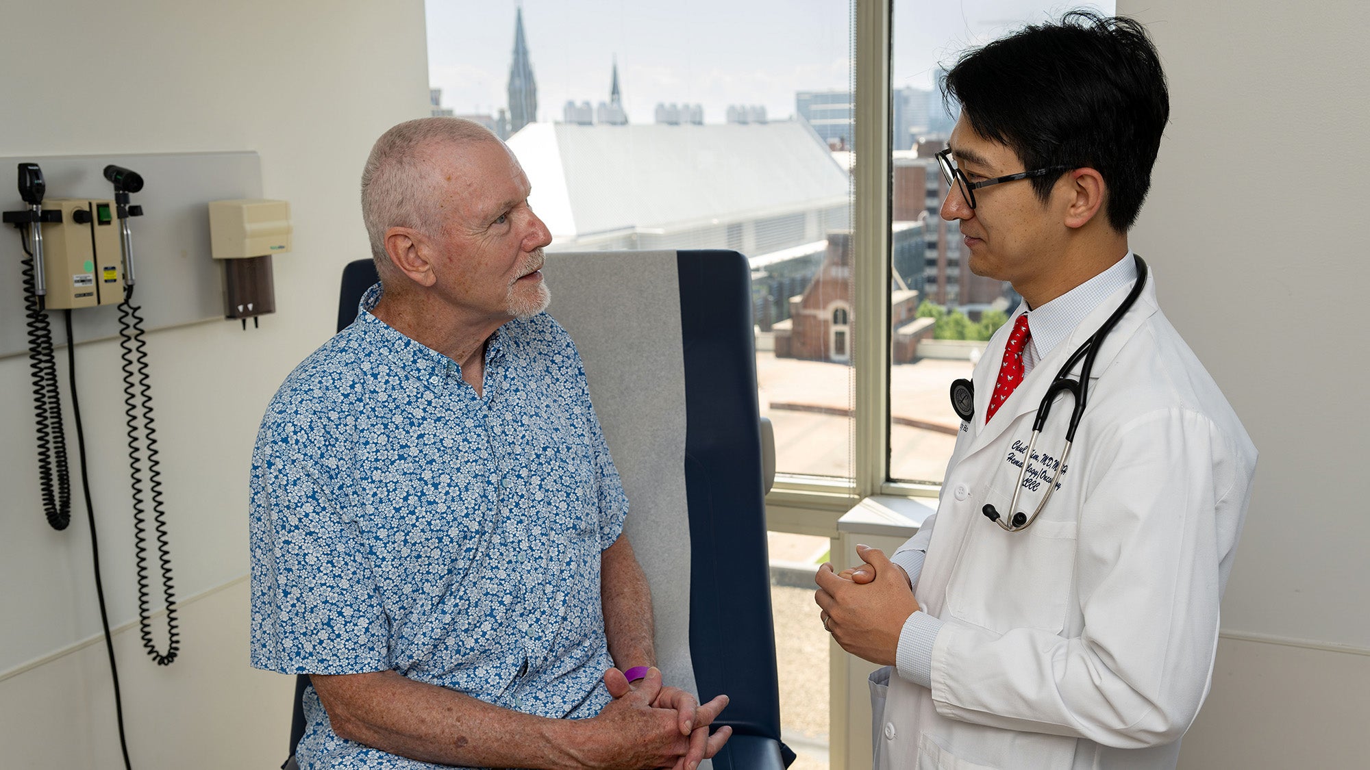 Dr. Chul Kim speaks to a patient in an exam room