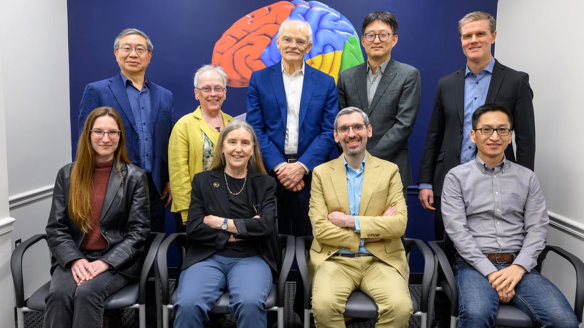 A group of nine faculty stand together