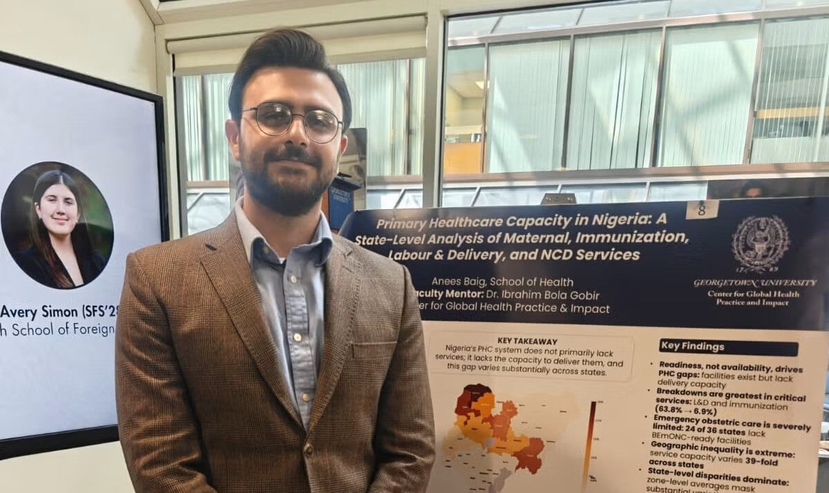 Anees Baig stands before his research poster